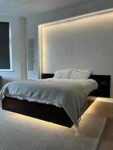 um quarto com uma cama grande e uma grande cabeceira. em Luxurious London Studios em Harrow