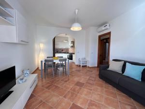 een woonkamer met een bank en een tafel bij Casa vacanze - Le Bacche di Maiorca in Budoni +4 foto's