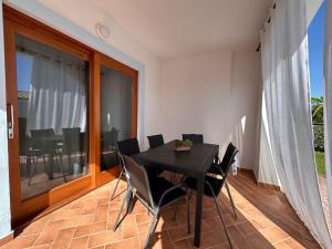 een eetkamer met een zwarte tafel en stoelen bij Casa vacanze - Le Bacche di Maiorca in Budoni