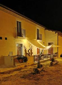a large yellow building with lights on it at night at La Dimora dei Baldi - Rooms & Relax in Fagnano Alto