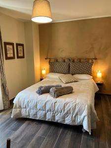 a bedroom with a large white bed with two pillows at La Dimora dei Baldi - Rooms & Relax in Fagnano Alto
