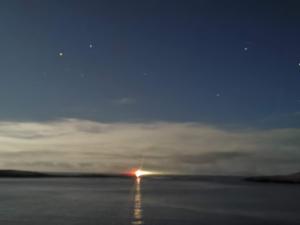 ein Spiegelbild der Sonne im Wasser in der Nacht in der Unterkunft Horizon View Lodge Bed and Breakfast Glanleam Road Knightstown Valentia Island County Kerry V23 W447 Ireland in Valentia Island