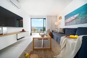 a living room with a blue couch and a table at Amapola Coast - recién reformado, frente a la playa in San Agustin