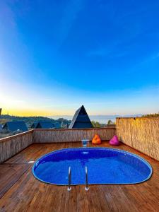 a blue pool on a deck with pyramids in the background at Joy Sapanca in Sapanca