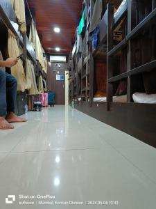 een persoon die op de vloer van een winkel gangpad zit bij ASRA DORMITORY For Male And Female in Mumbai