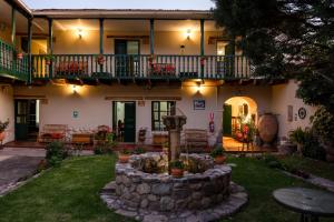 a house with a stone wall and a patio at Hospedaje La Florida in Urubamba