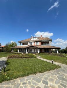duży dom siedzący na polu trawy w obiekcie Rouge Cottage nel Roero w mieście Sanfrè