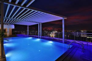 a swimming pool on the roof of a building at night at Olive Downtown in Cochin