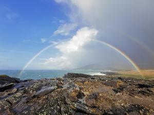 um arco-íris sobre uma costa rochosa com o oceano em Horizon View Lodge Bed and Breakfast Glanleam Road Knightstown Valentia Island County Kerry V23 W447 Ireland em Ilha de Valentia