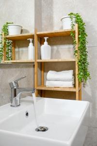 łazienka z umywalką i półką z ręcznikami w obiekcie DoMe Affittacamere w mieście Iglesias