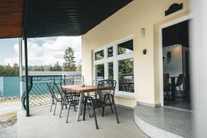 a patio with a table and chairs on a balcony at Black Tiger Seaside - Ferienwohnungen direkt am See in Garden