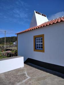 een wit huis met een raam en een dak bij Casa da Lapa in Angra do Heroísmo