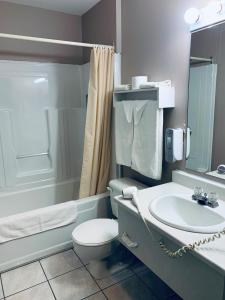 a bathroom with a white toilet and a sink at Hôtel Saint-Côme in Saint Come