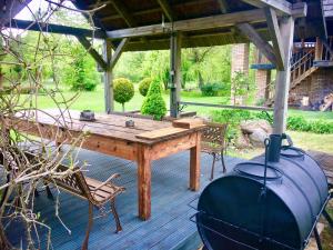 a wooden table and chairs on a patio at Griķi in Kalnišķi +17 photos
