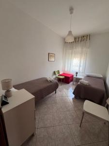a small room with two beds and a table at Romagnosi apartment in Porto Torres
