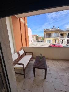 a balcony with two chairs and a table on a building at Romagnosi apartment in Porto Torres