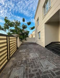 an empty driveway of a house with a fence at VILLA seeb 2 MIN walk to the beach in Seeb
