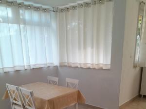uma mesa e cadeiras num quarto com cortinas em Apartments Viganj em Viganj