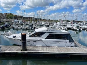 un barco blanco atracado en un muelle con otros barcos en Yacht Moineau VI, en Deauville