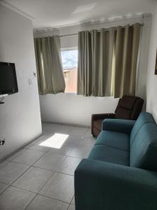 een woonkamer met een bank en een tv bij Excelente apartamento centro Paulo Afonso in Paulo Afonso