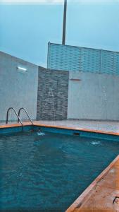 uma piscina com água azul em frente a um edifício em فيلا رسن em Al Hada