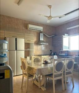 a kitchen with a table and chairs and a refrigerator at VILLA seeb 2 MIN walk to the beach in Seeb