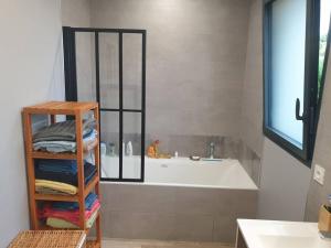 マコンにあるlocation villa moderne piscineの浴槽、洗面台、鏡のあるバスルーム +20枚の写真