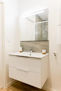a white bathroom with a sink and a mirror at L'élégant - Beau logement avec vue Sarthe - Gare - Tram - Centre ville in Le Mans +17 photos