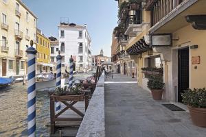 a narrow street with buildings and plants in a city at Hotel American-Dinesen in Venice