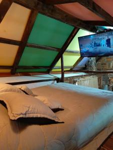 Cama en habitación con TV de pantalla plana en Cabaña en la Calera BersaNina, en La Calera