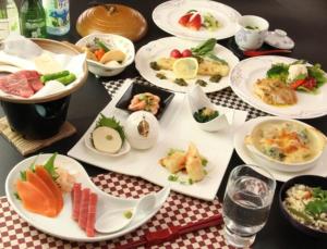 a table full of plates of food on a table at Hotel Sunny Valley in Otari