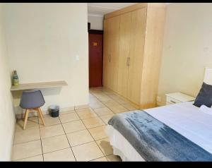 a bedroom with a bed and a chair in it at Franjipani in Margate