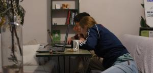 dwie kobiety siedzące przy stole z laptopem w obiekcie Harmony Boutique Hostel w mieście Batumi
