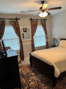 een slaapkamer met een bed en een plafondventilator bij Comfortable Private Room in a Shared House in Youngsville