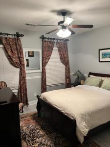 een slaapkamer met een bed en een plafondventilator bij Comfortable Private Room in a Shared House in Youngsville