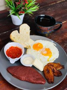 un piatto di prodotti per la colazione con uova, carne e pane tostato di Hoff Hostal y Restaurante a Santa Ana