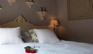 a bedroom with a white bed with a red flower on it at Suitehotel Posthoorn in Monnickendam