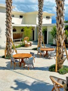 a patio with two tables and chairs and palm trees at Bali Poshtel in San Juan