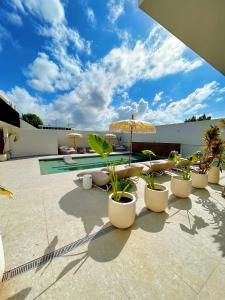 a patio with chairs and umbrellas and a pool at Bali Poshtel PR in San Juan