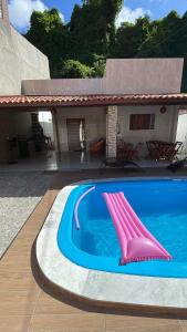 a swimming pool with a pink slide in front of a house at Casa de Férias á 400m pra Praia de Cabo Branco in João Pessoa