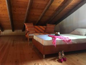 ein Schlafzimmer mit einem Bett und einem Sofa im Dachgeschoss in der Unterkunft Impressive Platanias Villa Villa Bulma 2 Bedrooms Private Pool in Platanias