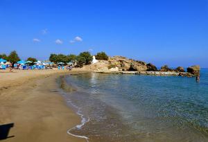ein Strand mit einer Gruppe von Menschen im Wasser in der Unterkunft Impressive Platanias Villa Villa Bulma 2 Bedrooms Private Pool in Platanias + 12 Fotos