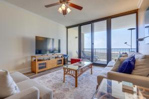 a living room with a couch and a tv at Beachfront Dauphin Island Condo with 2 Pools and Sauna in Dauphin Island