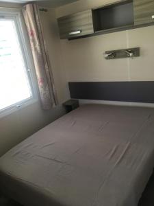 a small bedroom with a bed with a window at PROCHE du PONT GENOIS in Sartène