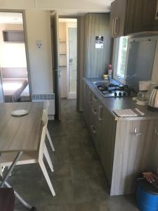 a small kitchen with a table and a stove at PROCHE du PONT GENOIS in Sartène