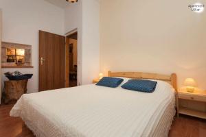- une chambre avec un lit blanc et 2 oreillers bleus dans l'établissement Apartment Uckar, à Barban