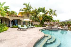 une maison dotée d'une piscine avec des chaises et un parasol dans l'établissement Stunning Villa Cielos - Close to the Beach, à San José del Cabo
