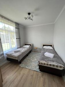 a bedroom with two beds and a rug at AiDaMaX 2 in Cholpon-Ata