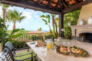 einen Tisch mit Speisen und einem Getränk auf der Terrasse in der Unterkunft Stunning Villa Cielos - Close to the Beach in San José del Cabo