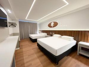 um quarto de hotel com duas camas e uma secretária em Fazzenda Park Resort em Gaspar
